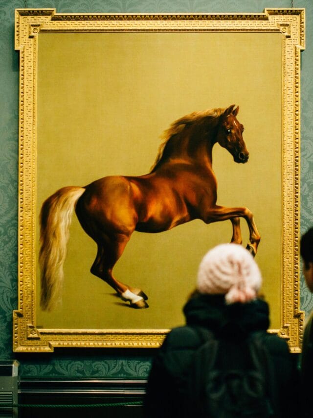 Visitors view a majestic horse painting at a museum, showcasing art appreciation and cultural exploration.